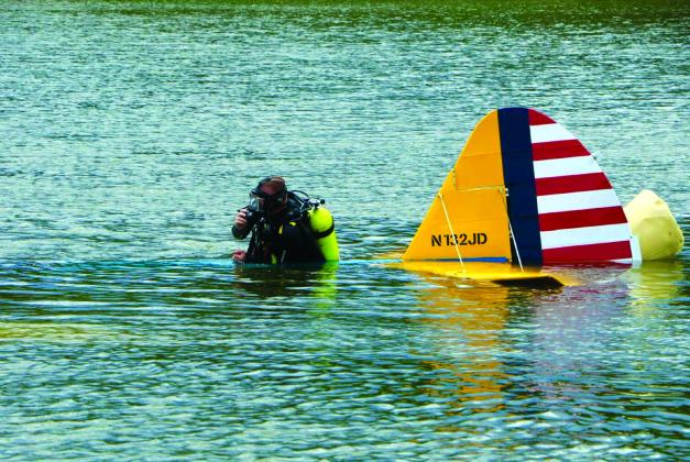 A member of the OHP Dive Team works Sunday, to float the 1941 vintage aircraft that crashed into Keystone Lake Saturday near Prue.
